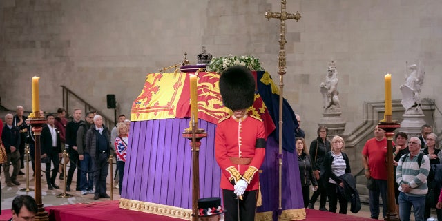 Members of the public file past the coffin of Queen Elizabeth II, draped in the Royal Standard with the Imperial State Crown and the Sovereign's orb and scepter, lying in state on the catafalque, in Westminster Hall, at the Palace of Westminster, in London, Friday, Sept. 16, 2022, ahead of her funeral on Monday. 