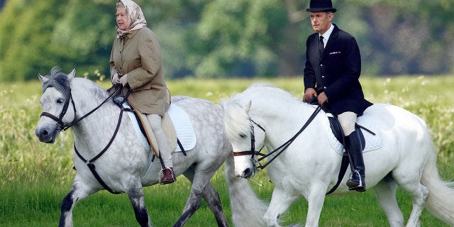 Queen Elizabeth II, accompanied by her Stud Groom Terry Pendry, seen horse riding in the grounds of Windsor Castle on June 2, 2006 in Windsor, England.