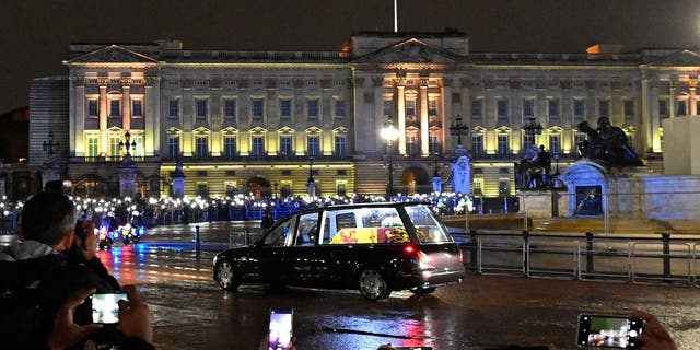 The coffin of Queen Elizabeth II arrives in the Royal Hearse at Buckingham Palace in London on September 13, 2022, where it will rest in the Palace's Bow Room overnight.