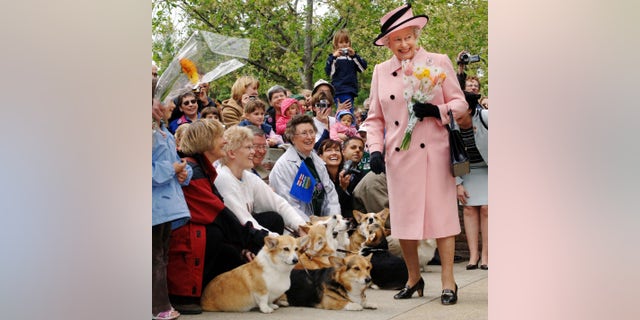 Queen Elizabeth II greeted by local corgi enthusiasts as she departs the Legislature Building during a trip to Canada in 2005.