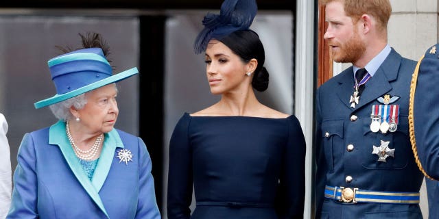 Meghan Markle y el príncipe Harry renunciaron a sus deberes reales en 2020 y se mudaron a California.  Están representados aquí con la difunta reina Isabel II. 