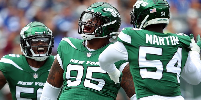 Defensive lineman Quinnen Williams celebrates with linebacker Quincy Williams, left, and defensive end Jacob Martin after a sack against the New York Giants at MetLife Stadium on August 28, 2022 in East Rutherford, New Jersey.
