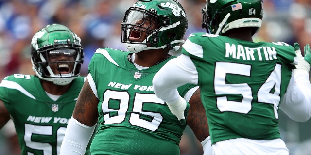 El liniero defensivo Quinnen Williams celebra con el apoyador Quincy Williams, a la izquierda, y el ala defensiva Jacob Martin después de una captura contra los New York Giants en el MetLife Stadium el 28 de agosto de 2022 en East Rutherford, Nueva Jersey.