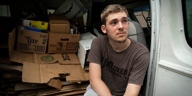 UnBoxed owner Ashton Gilbert rests in his van filled with cardboard boxes.