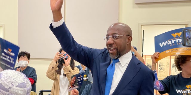 Democratic Sen. Raphael Warnock greets supporters as he arrives at a senior center in Norcross, Georgia, on Sept. 27, 2022.