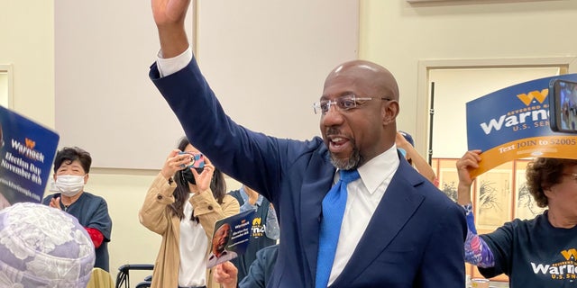 Democratic Sen.  Raphael Warnock greets supporters as he arrives at a senior center in Norcross, Georgia, on Sept.  27, 2022.