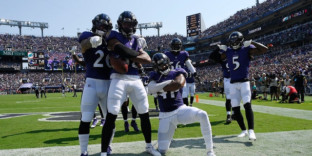 Baltimore Ravens safety Marcus Williams (32) celebrates with teammates after intercepting a pass during the first half against the Miami Dolphins in Baltimore on September 18, 2022.