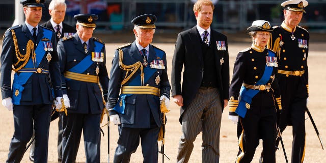 Prince William, King Charles III, Prince Harry and Princess Anne walk behind the queen's coffin during a procession.