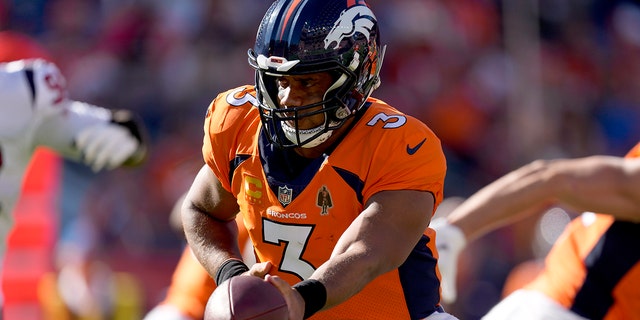 Denver Broncos quarterback Russell Wilson (3) hands off against the Houston Texans during the second half of an NFL football game, Sunday, Sept. 18, 2022, in Denver.