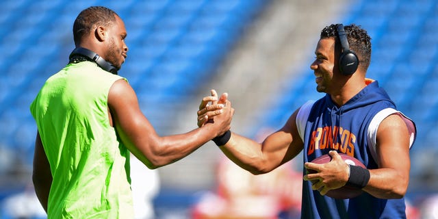 Geno Smith #7 of the Seattle Seahawks (L) and Russell Wilson #3 of the Denver Broncos shake hands before a game at Lumen Field on September 12, 2022 in Seattle, Washington.