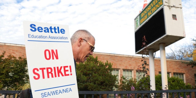 Math teacher Royce Christensen pickets outside Roosevelt High School on what was supposed to be the first day of classes as teachers from Seattle Public Schools go on strike, Wednesday, Sept. 7, 2022, in Seattle.