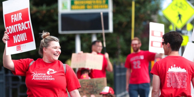 Lucy Magidman, wife of teacher Michael Magidman, shows her support as teachers from Seattle Public Schools picket outside Roosevelt High School on what was supposed to be the first day of classes, Wednesday, Sept. 7, 2022, in Seattle.