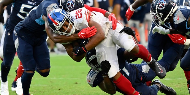 New York Giants running back Saquon Barkley (26) is stopped by the Tennessee Titans defense during the second half of an NFL football game Sunday, Sept. 11, 2022, in Nashville.