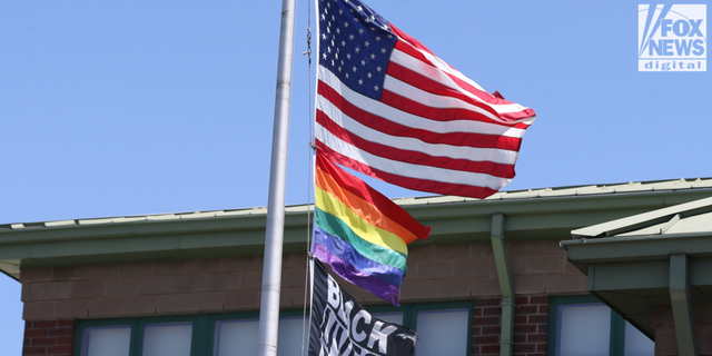 The American flag, rainbow flag and a Black Lives Matter flag wave over The Nativity School of Worcester. 