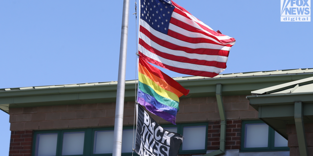 The US flag, the rainbow pride flag and a Black Lives Matter flag fly over The Nativity School of Worcester. 