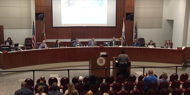 Members of the Loudoun County school board listen as virtual speakers address the board.