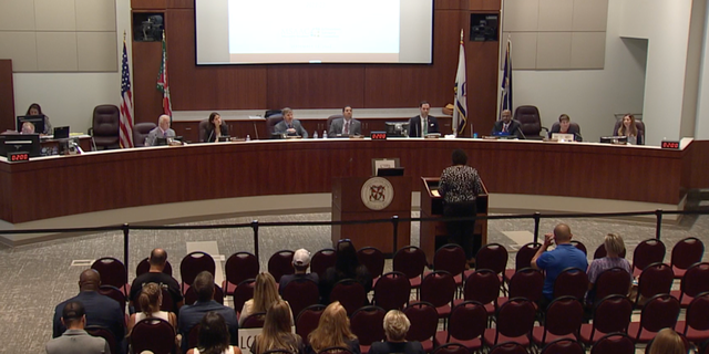 Members of the Loudoun County Board of Education hear a virtual speaker address a board meeting.