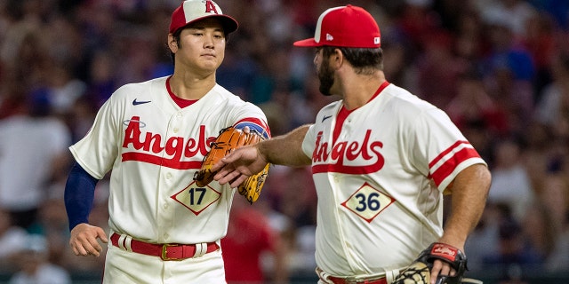 Los Angeles Angels starting pitcher Shohei Ohtani congratulates first baseman Mike Ford for getting Seattle Mariners' Carlos Santana out on a ground ball in Anaheim, California, Saturday, Sept. 17, 2022.