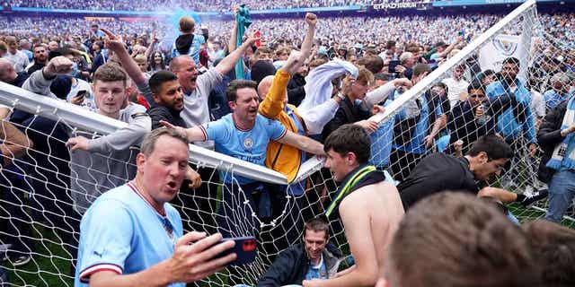 Manchester City fans celebrate after the English Premier League soccer match between Manchester City and Aston Villa in England, on May 22, 2022. The number of field invasions in soccer matches in England and Wales last season increased by 127% compared to the last full campaign before the coronavirus pandemic.