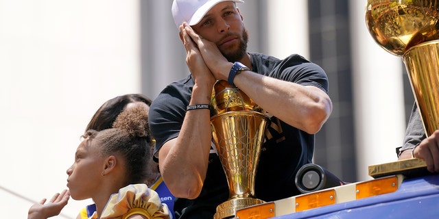 Golden State Warriors guard Stephen Curry poses with the NBA Finals Most Valuable Player Award trophy June 20, 2022, during the Warriors' championship parade in downtown San Francisco.