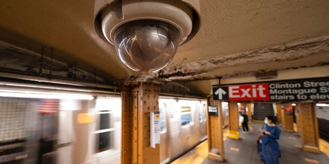 FILE - A video surveillance camera hangs from the ceiling above a subway platform in the Brooklyn borough of New York.
