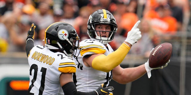 Pittsburgh Steelers linebacker T.J. Watt (90) celebrates after an interception with safety Tre Norwood (21) during the first half of an NFL football game against the Cincinnati Bengals, Sunday, Sept. 11, 2022, in Cincinnati.