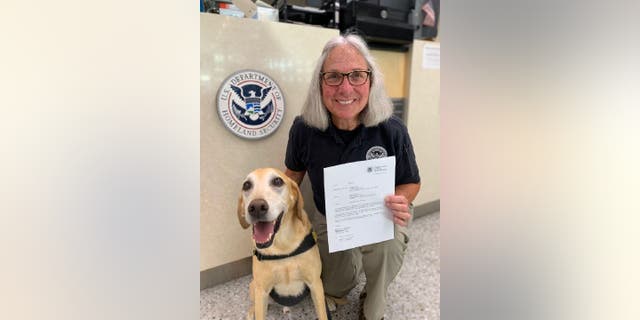 En Minnesota, el perro de la Administración de Seguridad del Transporte de EE. UU., Ebers, y su adiestrador, Jean Carney, posan juntos para una foto mientras celebran su retiro del Aeropuerto Internacional de Minneapolis-Saint Paul.