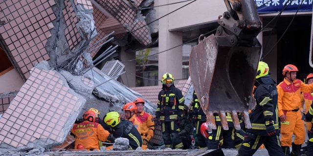 Firefighters are seen at a collapsed building during a rescue operation following an earthquake in Yuli township, Hualien County, eastern Taiwan, Sunday, Sept. 18, 2022. (Hualien City Government via AP)