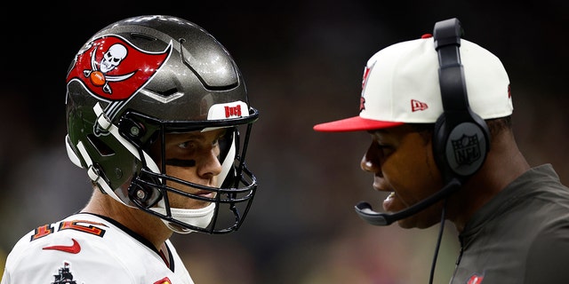 Tom Brady #12 of the Tampa Bay Buccaneers talks with head coach Todd Bowles of the Tampa Bay Buccaneers during the game against the New Orleans Saints at Caesars Superdome on Sept. 18, 2022 in New Orleans, Louisiana.