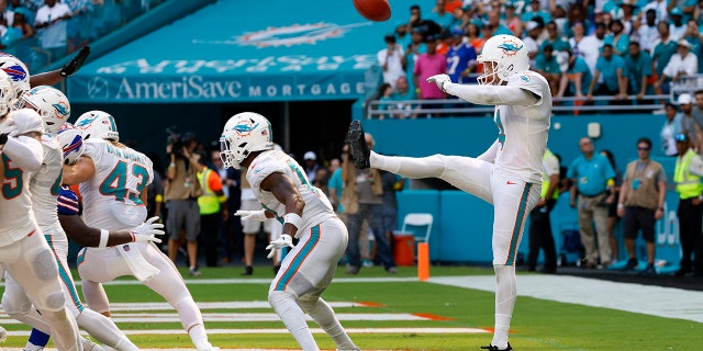 Miami Dolphins punter Thomas Morstead, #4, punts the ball off the backside of Miami Dolphins wide receiver Trent Sherfield, #14, for a safety during the game between the Buffalo Bills and the Miami Dolphins on Sept. 25, 2022 at Hard Rock Stadium in Miami Gardens, Florida.