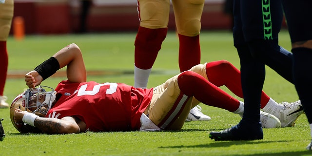 Il quarterback dei San Francisco 49ers Trey Lance giace in campo dopo essere stato affrontato nel primo tempo contro i Seattle Seahawks a Santa Clara, in California, il 18 settembre 2022.