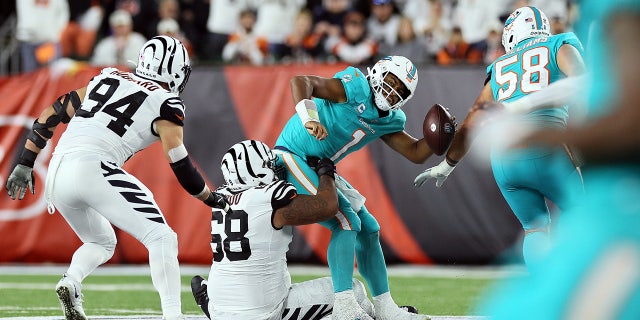 El mariscal de campo de los Miami Dolphins, Tua Tagovailoa #1, es despedido por el tackle defensivo de los Cincinnati Bengals, Josh Duboe #68, durante el segundo cuarto del partido contra los Cincinnati Bengals el 29 de septiembre de 2022 en el Baycore Stadium de Cincinnati, Ohio. 