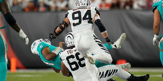Miami Dolphins quarterback Tua Tagovailoa (1) is sacked by Josh Topo of the Cincinnati Bengals (68) during the first half of an NFL football game, Thursday, September 29, 2022, in Cincinnati.