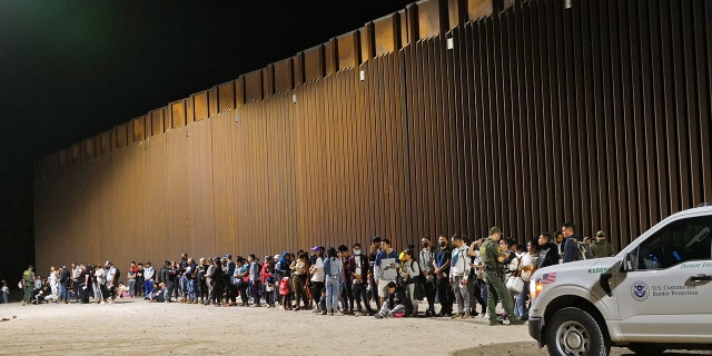 Migrants attempting to cross into the US from Mexico are detained by US Customs and Border Protection at the border August 20, 2022 in San Luis, Arizona.