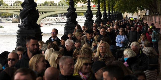 People wait in a queue opposite Westminster Palace to pay their respect to the late Queen Elizabeth II as her coffin lies in state in Westminster Hall, London, Friday, Sept. 16, 2022. 