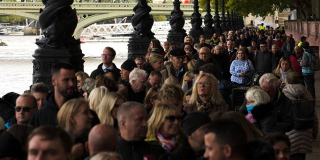 People wait in a queue opposite Westminster Palace to pay their respect to the late Queen Elizabeth II as her coffin lies in state in Westminster Hall, London, Friday, Sept. 16, 2022. 