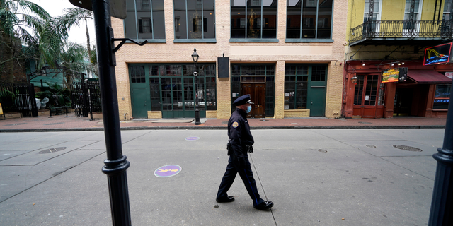 Un oficial de policía camina por una calle Bourbon casi desierta durante el Mardi Gras en el Barrio Francés de Nueva Orleans, el martes 16 de febrero de 2021. Con la esperanza de reforzar una fuerza policial cada vez más reducida en medio de un aumento en los delitos violentos, los funcionarios de Nueva Orleans anunciaron tres plan anual de $80 millones el jueves 8 de septiembre de 2022, que ofrece aumentos para todos los oficiales, atención médica gratuita y $30,000 en pagos de incentivos para nuevas contrataciones. 