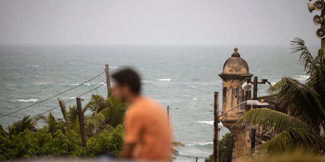 A man stands in front of a beach before the arrival of Hurricane Fiona in San Juan, Puerto Rico.