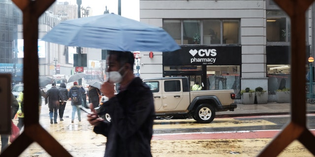 People walk through the rain and sleet in Manhattan as temperatures begin to fall on Feb. 4, 2022, in New York City.