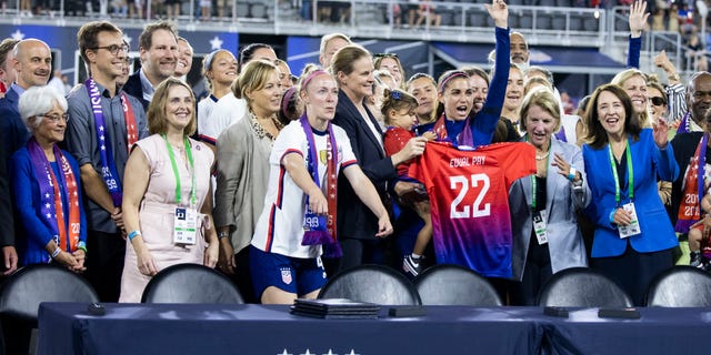 Members of U.S. Soccer and the U.S. Women's National Team Players Association hold up an Equal Pay jersey after signing a collective bargaining agreement providing equal pay between the men's and women's national soccer teams at Audi Field Sept. 6, 2022, n Washington, D.C.