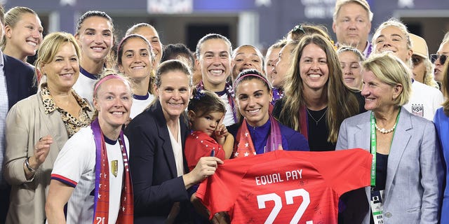 Members of U.S. Soccer, the U.S. Women's National Team Players Association and other dignitaries pose for a photo after signing a collective bargaining agreement providing equal pay for the men's and women's national soccer teams at Audi Field Sept. 6, 2022, in Washington, D.C.