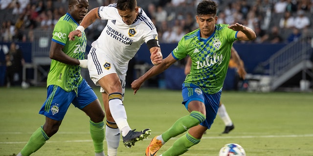 Javier Hernández #14 of Los Angeles Galaxy scores a goal as Xavier Arreaga #3 of Seattle Sounders defends during the match at the Dignity Health Sports Park on Aug. 19, 2022 in Carson, California. The match ended in a 3-3 tie.