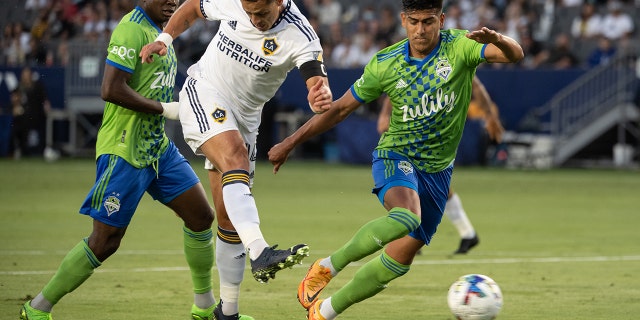 Javier Hernández #14 of Los Angeles Galaxy scores a goal as Xavier Arreaga #3 of Seattle Sounders defends during the match at the Dignity Health Sports Park on Aug. 19, 2022 in Carson, California. The match ended in a 3-3 tie.