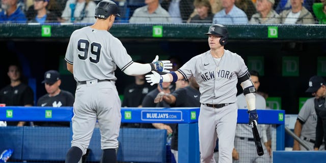 Aaron Judge, #99 of the New York Yankees, celebrates scoring with Josh Donaldson, #28, against the Toronto Blue Jays in the third inning during their MLB game at the Rogers Centre on Sept. 27, 2022 in Toronto.