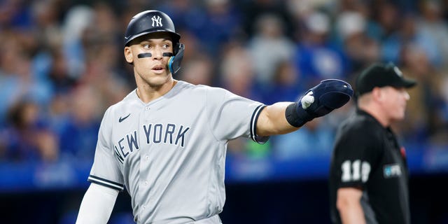 Aaron Judge, #99 of the New York Yankees, celebrates as he scores off a Gleyber Torres, #25, single in the sixth inning of their MLB game against the Toronto Blue Jays at Rogers Centre on Sept. 27, 2022 in Toronto.