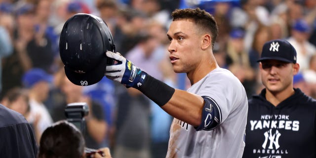 Aaron Judge #99 of the New York Yankees gives his mother a hat after hitting his 61st home run of the season in the seventh inning against the Toronto Blue Jays at the Rogers Center in Toronto, Ontario, Canada, Sept. 28, 2022 . Judge now tied Roger Maris for an American League record.