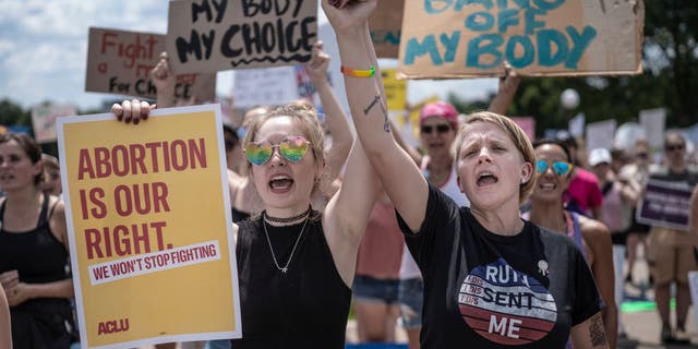 At the Capitol Building in St. Paul, Minnesota, McKayla Wolfe left and Karen Wolfe joined hands to rally for abortion rights