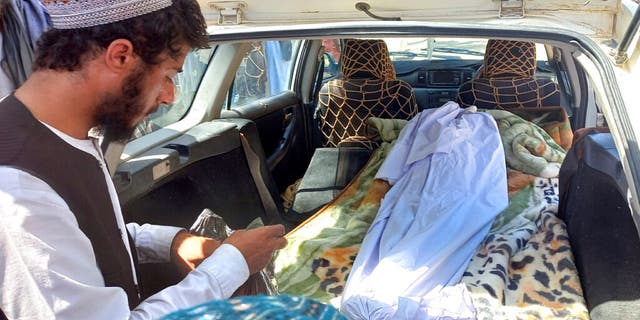 The covered body of a girl lies in the back of a vehicle after she was killed by an unexploded bullet in the Helmand province of southern Afghanistan on Saturday, September 3, 2022. 