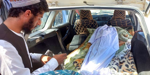 Covered body of a girl lies in the back of a vehicle after she was killed by unexploded shell in Helmand province, southern Afghanistan, Saturday, Sept. 3, 2022.