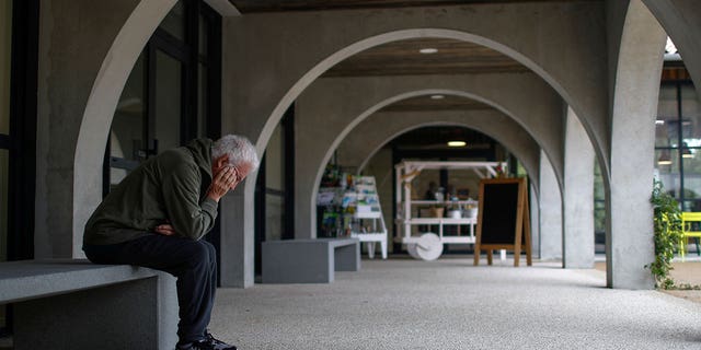 An Alzheimer's patient rests on a bench after walking at the Village Landais Alzheimer site in Dax, France, on Sept. 24, 2020. 